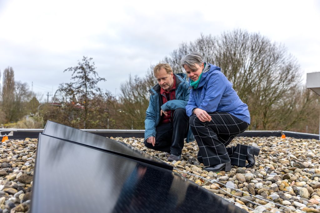 Twee mensen kijken naar een zonnepaneel