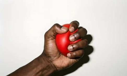 Hand met stressbal erin waar in wordt geknepen